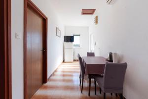 a dining room with a table and chairs and a door at Apartman Viola 1 in Ugljan +3 photos