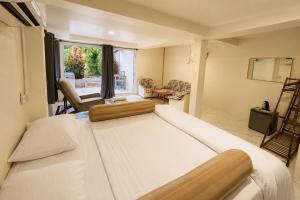 a bedroom with a large white bed and a living room at Kopan House View Point by WildFlower in Thong Sala +11 photos