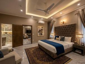 a bedroom with a large bed and a living room at Regency Suite Hotel in Lahore