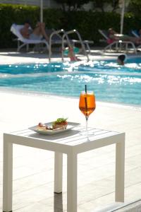 un bicchiere di vino appoggiato su un tavolo accanto a una piscina di Forte Hotel a Vieste