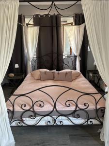 a bedroom with a bed with a black metal frame at La Ferme de Jad in Louhans +14 photos
