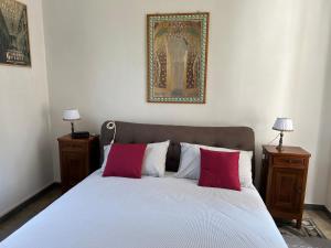 a bed with two red pillows in a bedroom at Villa Rosazza in San Salvatore Monferrato