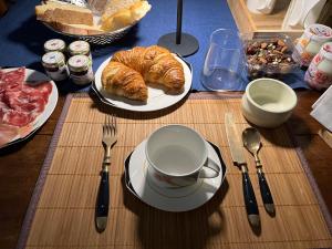 a table with a plate of bread and a cup of coffee at Villa Rosazza in San Salvatore Monferrato