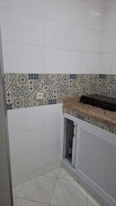 a bathroom with a counter and a tile wall at Belle apt près de la mer in Tangier