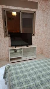a flat screen tv on a dresser in a room at Belle apt près de la mer in Tangier +4 photos