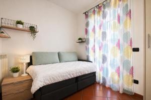 a small bedroom with a bed and a window at Shila House in Luino
