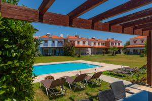 a view of a swimming pool with chairs and houses at Villa Kadrina in Kolymbia