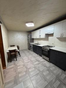 a large kitchen with a table and a table and chairs at Большой дом в Степанаване in Stepʼanavan +2 photos