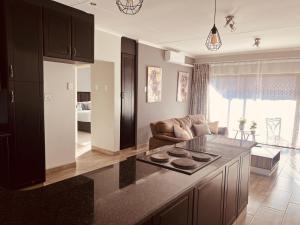 a kitchen and living room with a couch and a table at Just Bed & bath by mama R in Newcastle