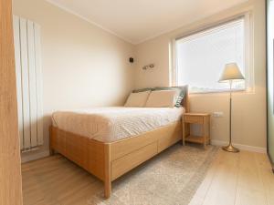 a bedroom with a bed with a lamp and a window at Apartament Bohaterów in Giżycko
