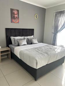 a bedroom with a large bed in a room at Just Bed & bath by mama R in Newcastle