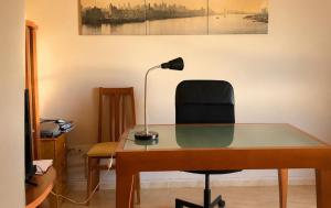 an office desk with a lamp and a chair at Apartamento Turistico San Cristobal in Plasencia