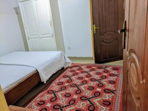 a bedroom with a bed and a red carpet at Chris Hotel in Runda +2 photos