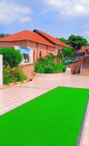 a building with a green lawn in front of a building at Chris Hotel in Runda