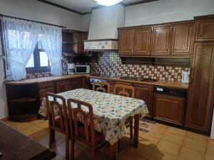 a kitchen with a table and a table and chairs at Villa Orfani in Orfánion +16 photos