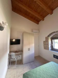 a bedroom with a bed and a desk with a television at Casal Sikelio in Cassibile +61 photos