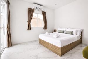 a white bedroom with two beds and a window at Luxury Pool Villa Pattaya Center C3- 3 Bedroom in Pattaya South +15 photos