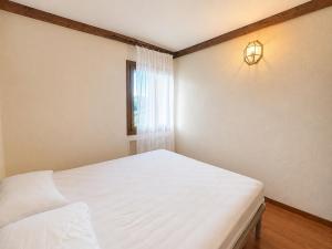 a bedroom with a white bed and a window at Hostdomus - B2-01 in Grange Sises