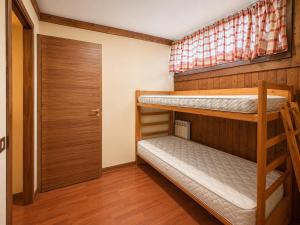 two bunk beds in a small room with a door at Hostdomus - B2-01 in Grange Sises