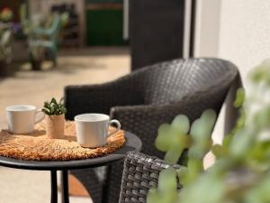 two coffee cups on a table with two chairs at BBB Parkside Studio city center in Budapest