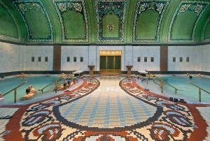 a pool in a building with people swimming in it at BBB Parkside Studio city center in Budapest
