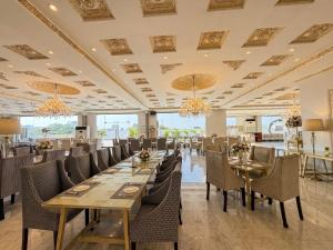 a dining room with tables and chairs and chandeliers at Regency Suite Hotel in Lahore +21 photos