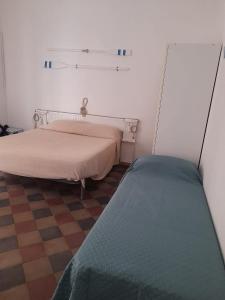 a bedroom with two beds and a checkered floor at Na' zà Ciccina in Palermo
