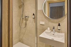 a bathroom with a shower and a sink and a mirror at Cinema City Hotel Europaplatz Karlsruhe - Brand New Boutique Hotel 2025 - in Karlsruhe +97 photos