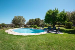 a pool with two chairs in a yard at Turismo Rurale CUDACCIOLU in Arzachena