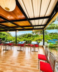 a room with tables and chairs and a large window at Parudeesa Pool Resort in Vattavada