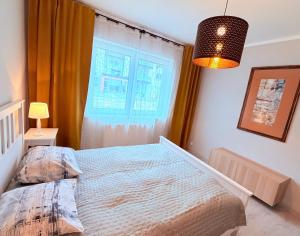 a bedroom with a bed and a window at Azymut in Darłowo