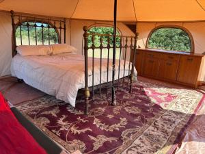 a bedroom with a bed in a tent at Sunset and Swallows in Eaton Bishop