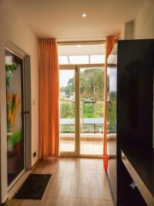 a living room with a large glass door to a balcony at Parudeesa Pool Resort in Vattavada