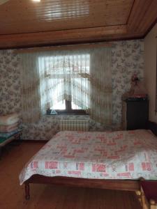 a bedroom with a large bed with a window at İsmayıllı bağ evi in İkinci Yeniyol