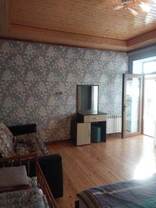 a living room with a couch and a tv on a wall at İsmayıllı bağ evi in İkinci Yeniyol