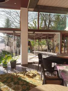 a living room with a table and chairs and windows at İsmayıllı bağ evi in İkinci Yeniyol