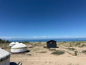 a group of tents on a beach with the ocean at КамбарАта in Tossor