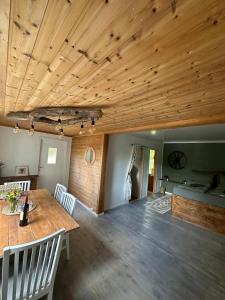 a living room with a wooden ceiling and a table at hytte ved innsjø in Skien +13 photos
