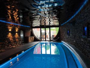 a swimming pool in a building with a large window at Liptovský mlyn in Bešeňová