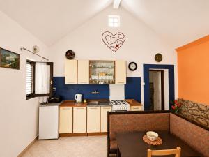 a kitchen with a table and a kitchen with a heart on the wall at Holiday home Moni in Karlobag