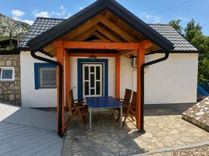 a pavilion with a table and chairs on a patio at Holiday home Moni in Karlobag +6 photos