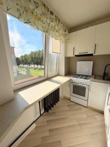 a kitchen with white cabinets and a large window at Kerese tn Apartment 1-2 persons in Narva