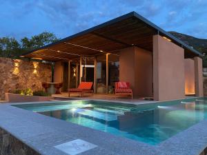 a villa with a swimming pool in front of a house at Alpa Nera in Galeria
