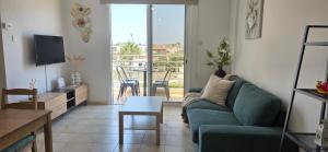 a living room with a green couch and a table at Carisa Lighthouse by Staycom in Perivolia