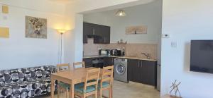 a kitchen and dining room with a table and chairs at Carisa Lighthouse by Staycom in Perivolia +2 photos