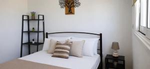 a bedroom with a bed with white sheets and pillows at Carisa Lighthouse by Staycom in Perivolia
