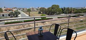 a table on a balcony with a view of a street at Carisa Lighthouse by Staycom in Perivolia