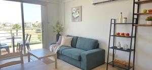 a living room with a blue couch and a table at Carisa Lighthouse by Staycom in Perivolia