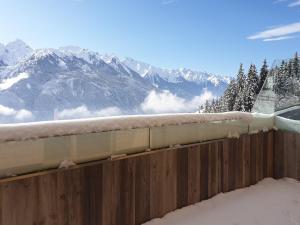 a fence covered in snow with mountains in the background at Kitzbühel alpine lodge with sauna in Mittersill