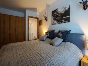 a bedroom with a large bed with blue pillows at Kitzbühel alpine lodge with sauna in Mittersill